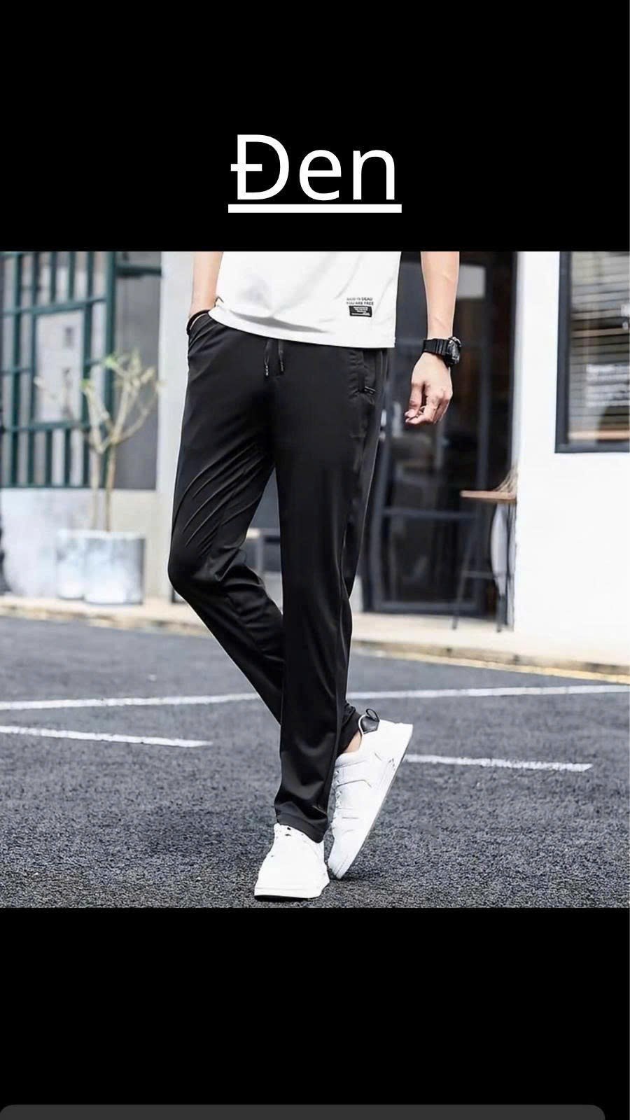 Người mẫu mặc quần gió nam màu Đen, form suông ống đứng, phối áo thun trắng và giày sneaker trắng